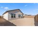 Exterior view of backyard and covered patio with a stucco privacy fence and desert landscaping at 3937 S 233Rd Ln, Buckeye, AZ 85326