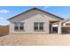 Exterior view of backyard and covered patio with a stucco privacy fence and desert landscaping at 3937 S 233Rd Ln, Buckeye, AZ 85326