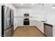 Bright kitchen featuring stainless steel appliances, white cabinets, quartz counters, and wood floors at 3937 S 233Rd Ln, Buckeye, AZ 85326