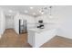 Modern kitchen featuring stainless steel appliances, white cabinets, quartz countertop, and hardwood floors at 3937 S 233Rd Ln, Buckeye, AZ 85326