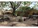 Charming backyard featuring a custom stone pizza oven, mature trees, and cozy seating areas, perfect for outdoor entertaining at 3957 N 148Th Dr, Goodyear, AZ 85395