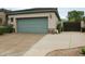 Attached garage with driveway, stone accents, and lush landscaping at 3957 N 148Th Dr, Goodyear, AZ 85395