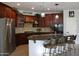 Bright kitchen featuring an island with seating, dark wood cabinets and granite countertops at 3957 N 148Th Dr, Goodyear, AZ 85395