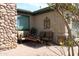 Covered patio with comfortable seating and stone accent wall, offering a relaxing outdoor living space at 3957 N 148Th Dr, Goodyear, AZ 85395