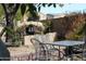 Backyard pizza oven and patio seating with metal chairs and table, surrounded by gravel, for outdoor entertaining at 3957 N 148Th Dr, Goodyear, AZ 85395