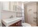 Modest bathroom features updated vanity, mirror, tile floor, toilet, and built-in shelving at 4031 N 81St Ave, Phoenix, AZ 85033