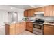Well-lit kitchen boasts wooden cabinets, stainless steel oven, granite countertops, and tile flooring at 4031 N 81St Ave, Phoenix, AZ 85033