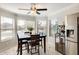 Cozy dining area with a dark wooden table, a ceiling fan, and multiple windows offering plenty of sunlight at 4332 W Carson Rd, Laveen, AZ 85339