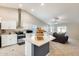 Open kitchen with white cabinets, stainless appliances, and an island, flowing into the living area at 4332 W Carson Rd, Laveen, AZ 85339