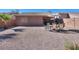 Spacious backyard featuring desert landscaping and patio seating under a covered patio at 43409 W Sagebrush Trl, Maricopa, AZ 85138