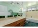 Vintage bathroom with double sink vanity, glass cabinet, and shower-tub combo at 4510 W Keim Dr, Glendale, AZ 85301
