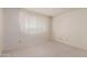 Bright bedroom featuring a window with white sheer curtains, and neutral carpet at 4510 W Keim Dr, Glendale, AZ 85301