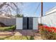 Backyard shed with double doors and red flowering bushes at 4510 W Keim Dr, Glendale, AZ 85301