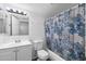 Bathroom featuring shower-tub combination with blue and beige patterned curtain, toilet, and white vanity with lighting at 461 W Holmes Ave # 383, Mesa, AZ 85210