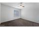 This bedroom features a large window, neutral carpet, and a ceiling fan, offering comfort and natural light at 461 W Holmes Ave # 383, Mesa, AZ 85210