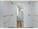 Walk-in closet with custom wooden hanging rods and a view into the modern en suite bathroom at 4955 E Indian School Rd # 5, Phoenix, AZ 85018