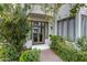 Inviting front entrance with lush landscaping, brick walkway, and elegant glass doors at 4955 E Indian School Rd # 5, Phoenix, AZ 85018