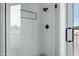 Modern shower with sleek matte black fixtures, white tile, and a glass enclosure allowing natural light at 4955 E Indian School Rd # 5, Phoenix, AZ 85018