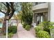 Landscaped brick walkway to the building entrance, surrounded by lush greenery and a glimpse of a community pool at 4955 E Indian School Rd # 5, Phoenix, AZ 85018