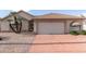 Charming single-story home featuring a two-car garage and desert landscaping with mature palm trees in front at 6200 S Championship Dr, Chandler, AZ 85249
