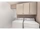 Laundry room featuring a white, front-loading washer and dryer and ample storage at 6200 S Championship Dr, Chandler, AZ 85249