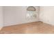 Empty room with light hardwood flooring and white walls and decorative window at 6200 S Championship Dr, Chandler, AZ 85249