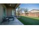 Covered patio featuring an outdoor dining set overlooking a well-maintained artificial grass lawn at 6774 S Pinehurst Dr, Gilbert, AZ 85298