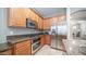 Galley style kitchen featuring stainless steel appliances, granite countertops, and wooden cabinetry at 6774 S Pinehurst Dr, Gilbert, AZ 85298