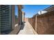 Narrow side yard features a concrete walkway, privacy wall, and desert landscaping at 6774 S Pinehurst Dr, Gilbert, AZ 85298