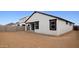 This backyard features a white home with black trimmed windows and a dirt landscape at 7414 W Whitehorn Trl, Peoria, AZ 85383