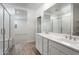 Bathroom showcasing double sink vanity with modern faucets, and glass shower enclosure at 7414 W Whitehorn Trl, Peoria, AZ 85383