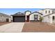 Inviting single-story home featuring a two-car garage, red door, and low maintenance desert landscaping at 7414 W Whitehorn Trl, Peoria, AZ 85383