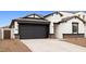 Attached two-car garage of this home, featuring a dark door and desert-style landscaping at 7414 W Whitehorn Trl, Peoria, AZ 85383