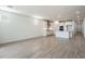 Open-concept living space with kitchen in the background, white walls, and wood-style tile flooring at 7414 W Whitehorn Trl, Peoria, AZ 85383