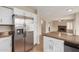 Modern kitchen with stainless appliances, white cabinetry, and a view into the spacious living area at 7637 W North Ln, Peoria, AZ 85345