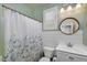 Well-lit bathroom featuring white fixtures, shower and a patterned shower curtain at 7769 S Reseda St, Gilbert, AZ 85298