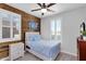 Charming bedroom features a wood accent wall, plantation shutters, and soft, calming light at 7769 S Reseda St, Gilbert, AZ 85298
