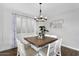 Inviting dining area with a wood table, white chairs, and elegant chandelier at 7769 S Reseda St, Gilbert, AZ 85298