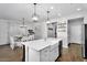 Bright, open kitchen featuring a large island, modern pendant lighting, and a farmhouse sink at 7769 S Reseda St, Gilbert, AZ 85298