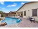 Beautiful backyard pool featuring a rock waterfall and brick-paved patio at 7769 S Reseda St, Gilbert, AZ 85298