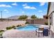 Inviting backyard pool area with a small waterfall feature and brick patio at 7769 S Reseda St, Gilbert, AZ 85298