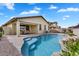 Sparkling pool with a rock waterfall feature, lush landscaping, and outdoor dining at 7769 S Reseda St, Gilbert, AZ 85298