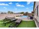 Inviting backyard pool area with outdoor lounge chairs and artificial turf at 7769 S Reseda St, Gilbert, AZ 85298