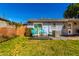 A charming backyard with a small deck, table, and chairs sits outside a light blue home at 8345 E Oak St, Scottsdale, AZ 85257