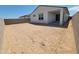 View of a spacious, bare backyard, enclosed by a block fence and ready for landscaping and personalization at 8530 W Trenton Ct, Florence, AZ 85132