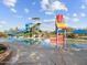 A colorful play structure and a large water slide stand next to a pool under a bright sky with fluffy white clouds at 8530 W Trenton Ct, Florence, AZ 85132
