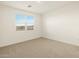 Bright bedroom features neutral carpet, light walls, and a window for natural light at 8576 W Trenton Ct, Florence, AZ 85132