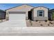 Charming single-story home featuring a two-car garage, desert landscaping, and neutral exterior paint at 8576 W Trenton Ct, Florence, AZ 85132