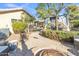 The backyard has a charming pergola, landscaped pathway, and a cozy fire pit area at 9231 E Carmel Ave, Mesa, AZ 85208