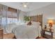 Bedroom featuring a bed with decorative headboard, ceiling fan, and floral curtains at 9231 E Carmel Ave, Mesa, AZ 85208